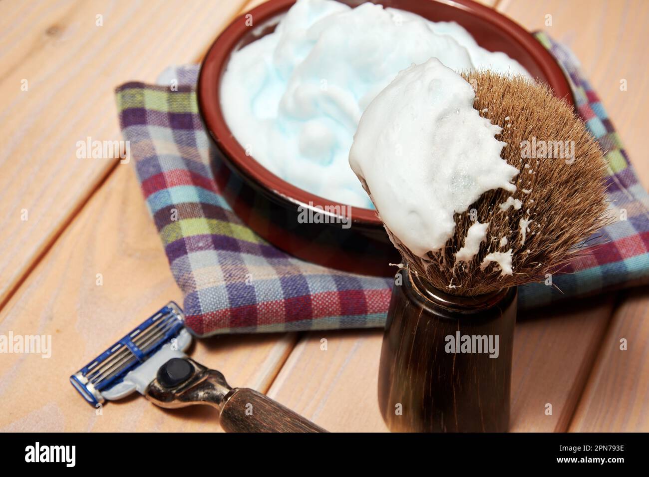 Closeup view of shaving equip, razor blade and brush and foam. Barbershop theme backgrounds Stock Photo