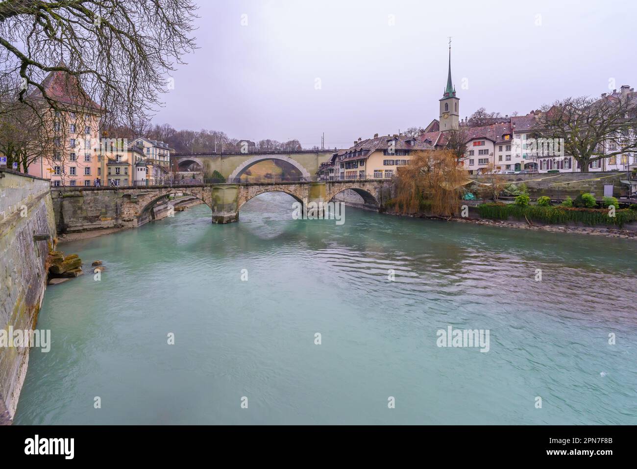 Bern, Switzerland - February 22, 2023: View of the Aare River, Untertorbrucke bridge, Nydegg Bridge, with Nydeggkirche church, in Bern, Switzerland Stock Photo