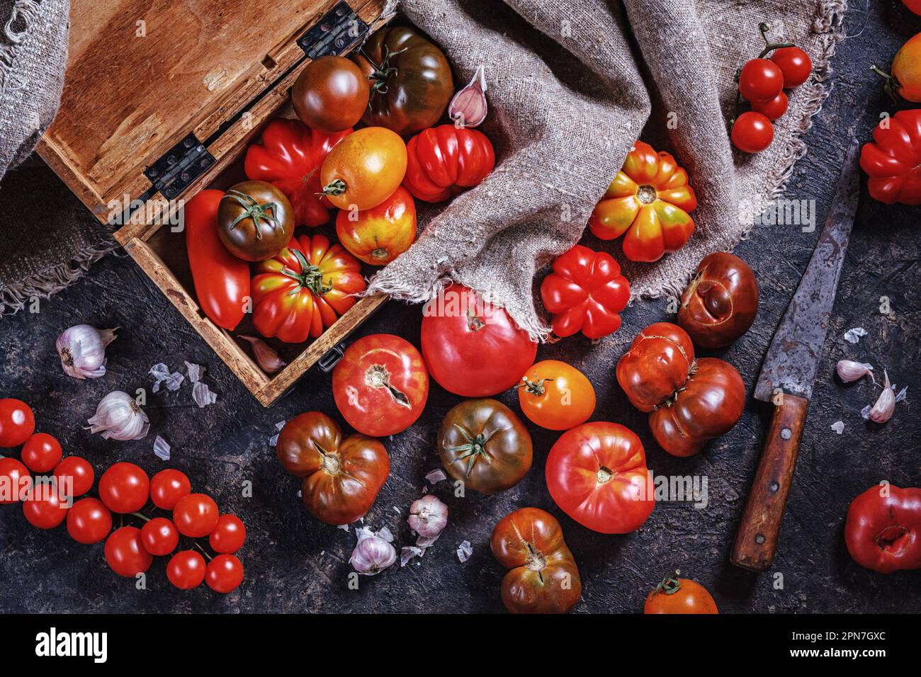 Many different breeds, shapes and sizes of tomatoes in an old wooden