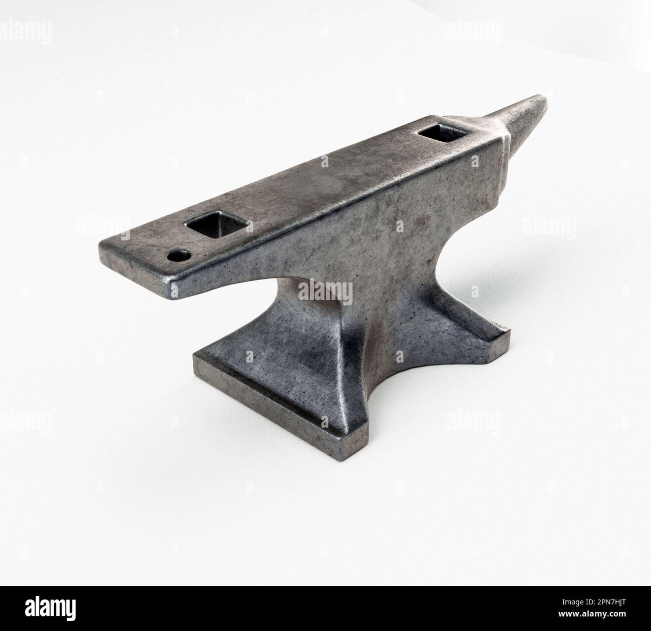 A heavy iron blacksmiths anvil on an isolated white studio background