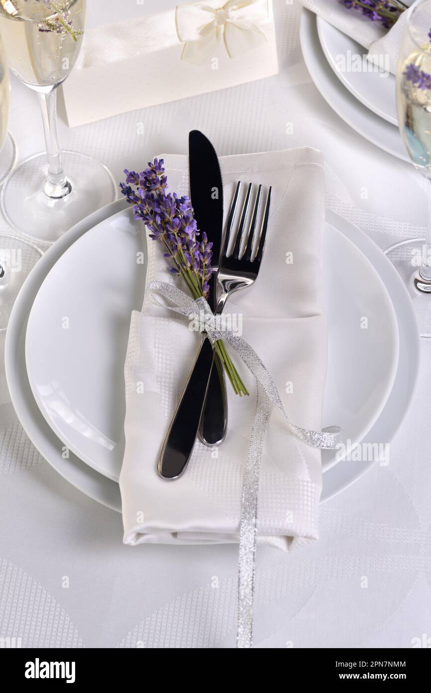 Lavender mood. Dining table in Provence style, with Lavender Champagne, folded napkin with cutlery, decorated with fresh lavender. Stock Photo