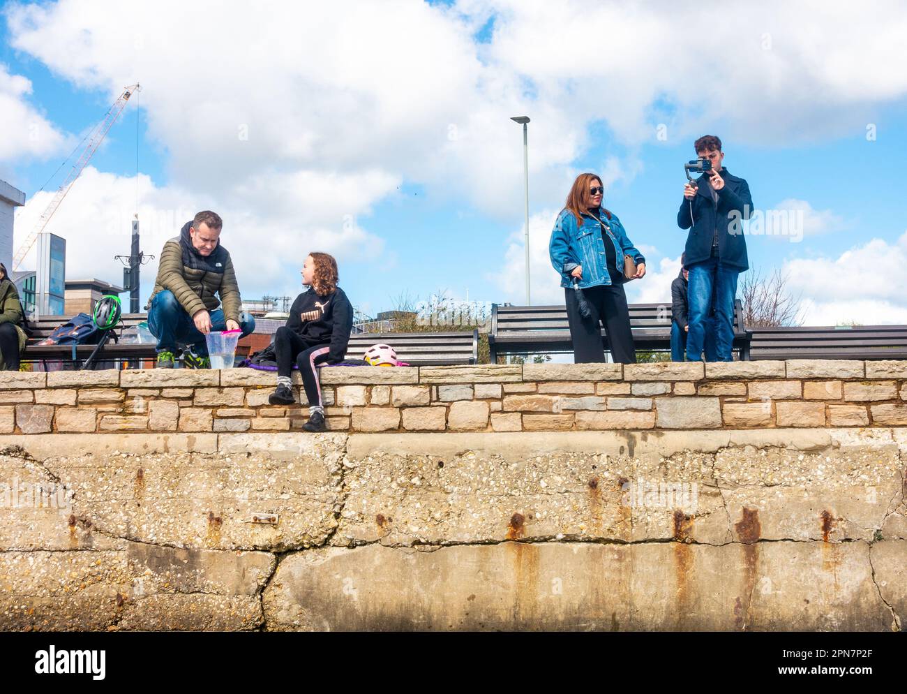 Tourists on the quayside at Poole Harbour in Dorset, UK. One family is