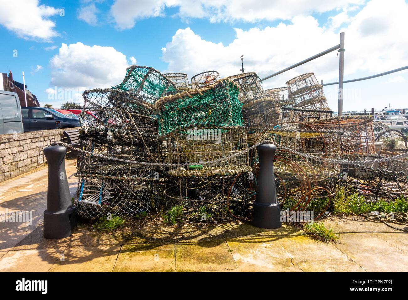 Crab pots piled up on the quayside at Poole Harbour in Dorset, UK Stock Photo