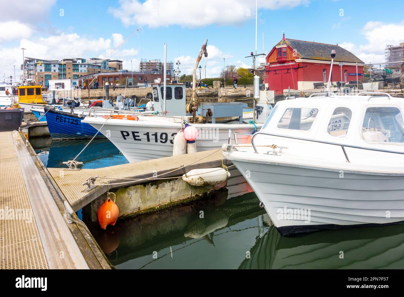 Boats moored on a pontoon in Poole Harbour in Dorset, UK Stock Photo