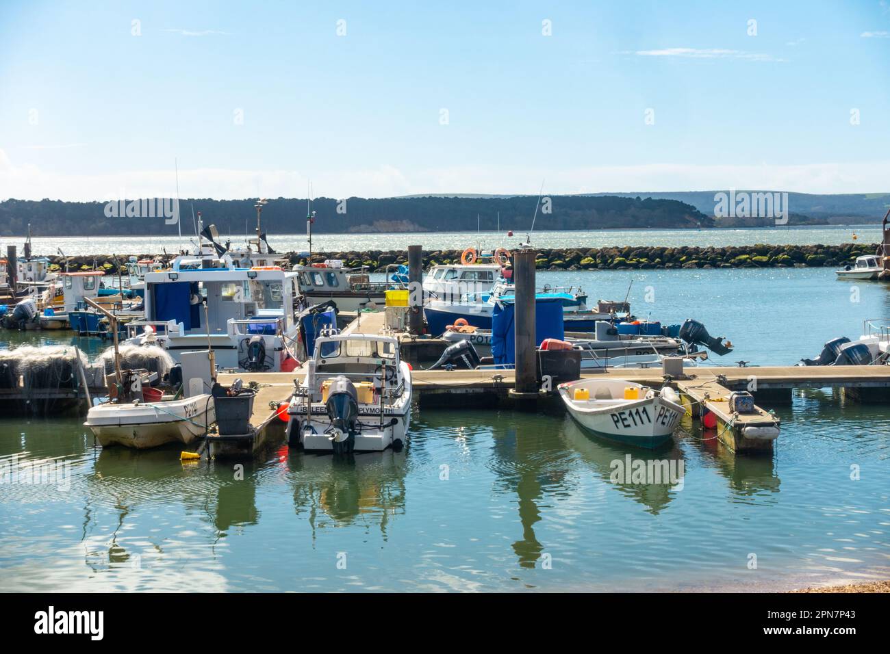 A view of boots in Poole Harbour with blue sky and reflections in the