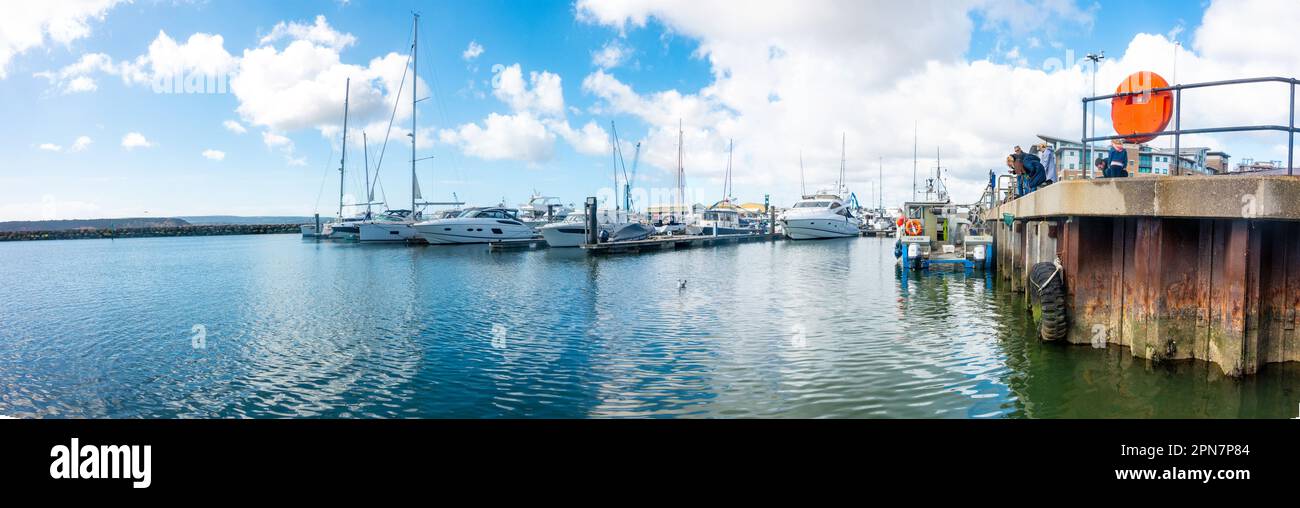 A panoramic view of boots in Poole Harbour with blue sky and clouds