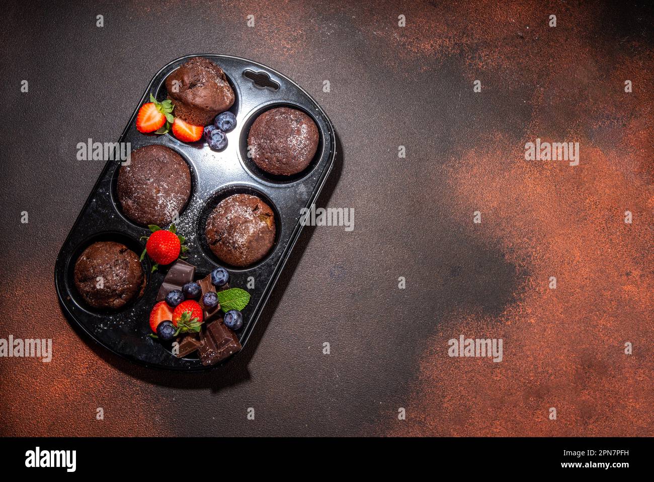 chocolate-muffins-with-berry-baking-muffin-pan-with-homemade-sweet