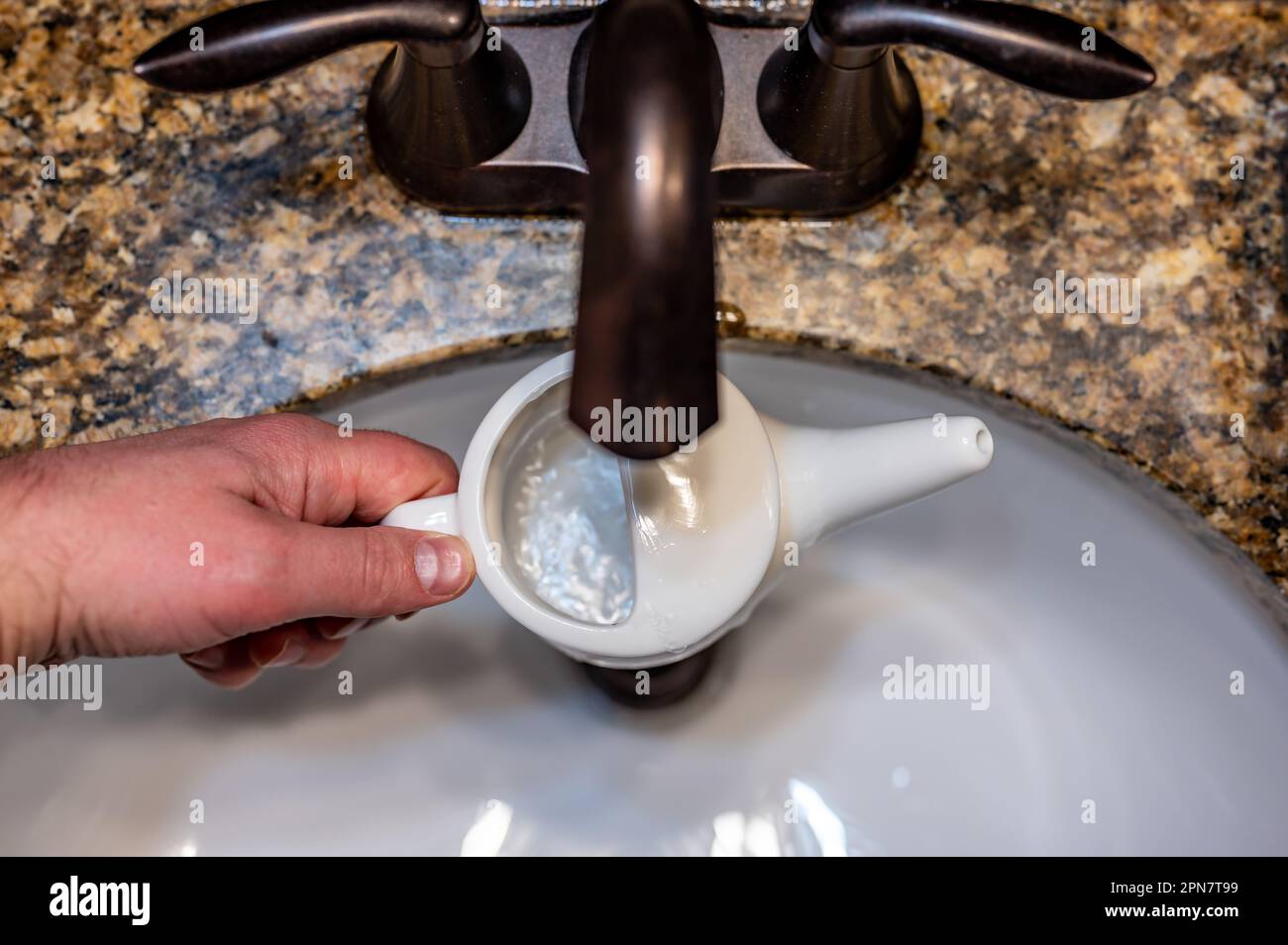 Improperly filling a neti pot with nonsterile tap water Stock Photo Alamy
