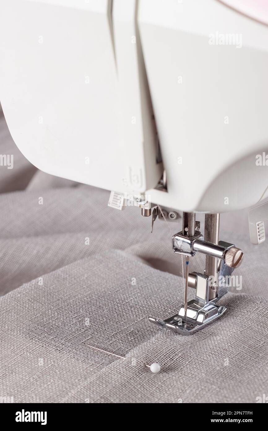 Modern sewing machine presser foot with linen fabric and thread ...