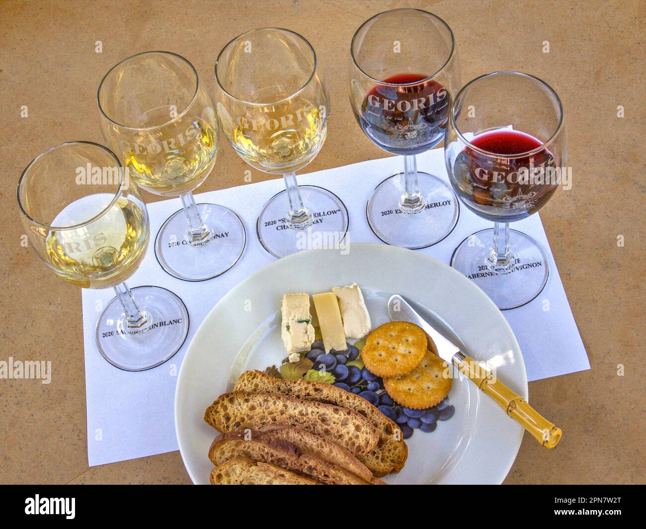 Wine tasting California USA alfresco table situation in Californian winery 'Georis', with selection of labelled 2020 red and white wine varieties with cheese and dry toasts/biscuits Carmel Valley California USA Stock Photo