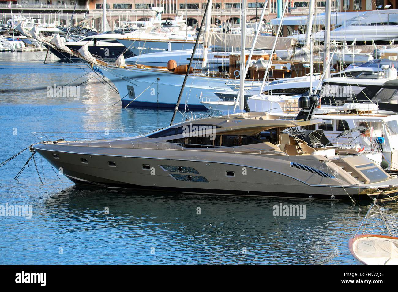 Monte-Carlo, Monaco - April 16, 2023: Golden Yacht 'Golden Fight' in the foreground and numerous superyachts lined up at Port Hercule, Monte-Carlo, Mo Stock Photo