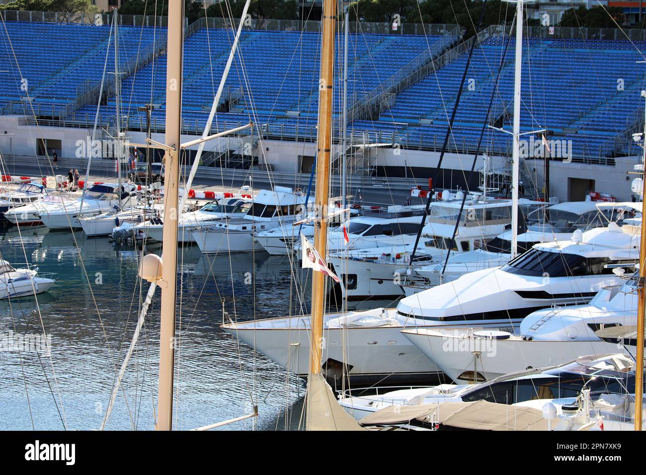 Monte-Carlo, Monaco - April 16, 2023: Numerous luxury boats and yachts at Port Hercule, Monte-Carlo, Monaco, with Formula 1 Grand Prix blue grandstand Stock Photo