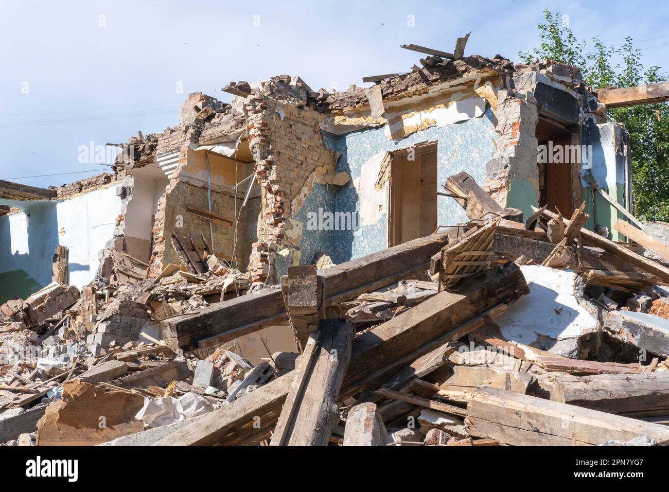 An abandoned house collapses. The house is destroyed. Cracks in wall of