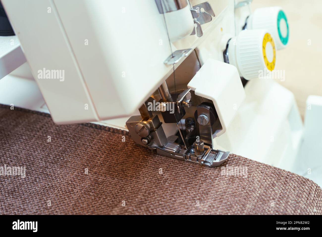 Professional equipment. Modern overlock sewing machine pressure foot in use with item of