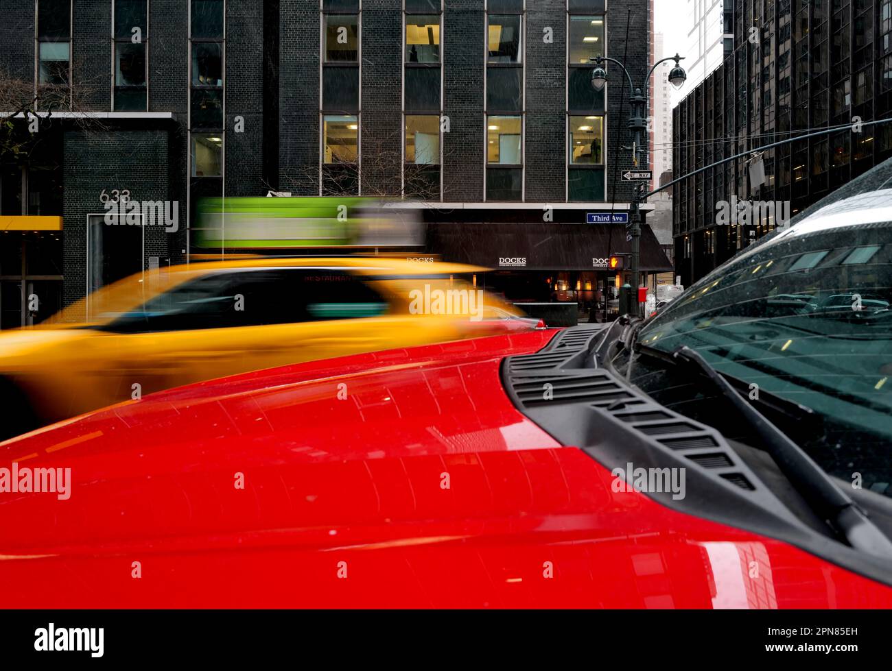 Red pickup truck hood and moving yellow cab on a New York City street Stock Photo