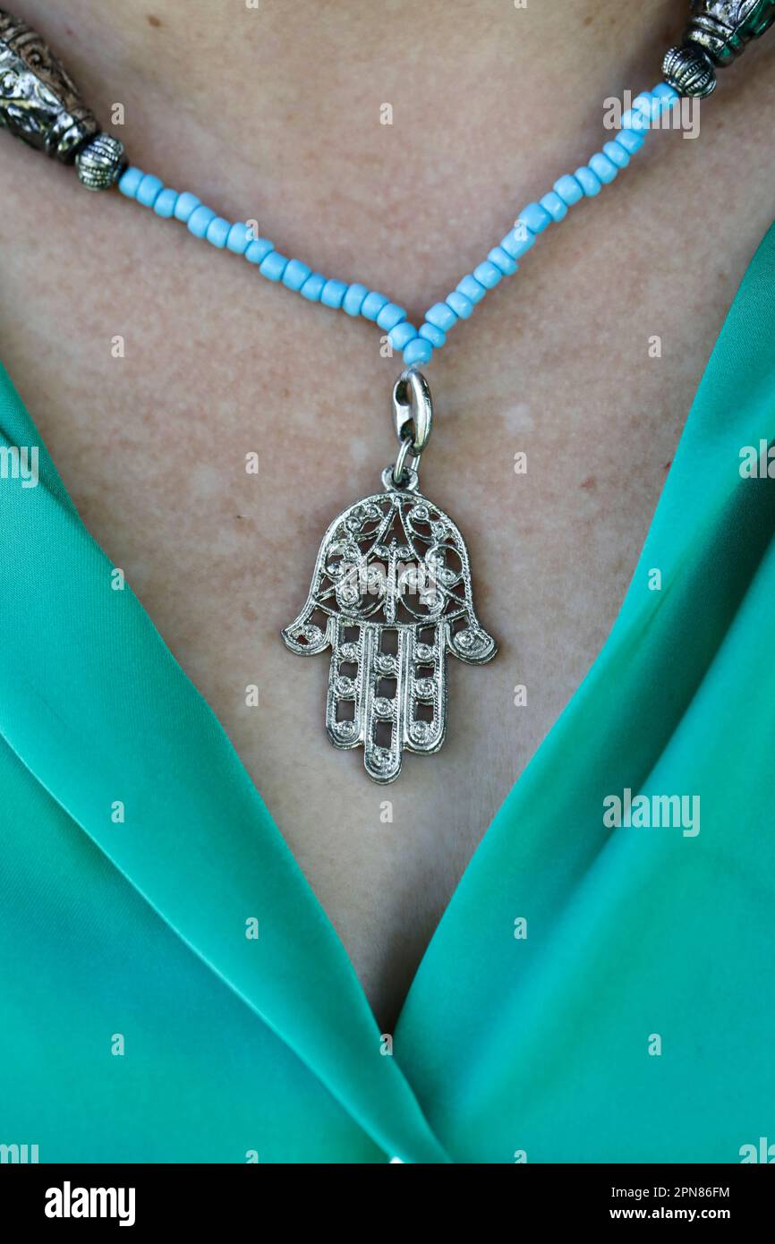 Woman wearing a muslim hamsa amulet, also known of the hand of fatima or the hand of mary Stock