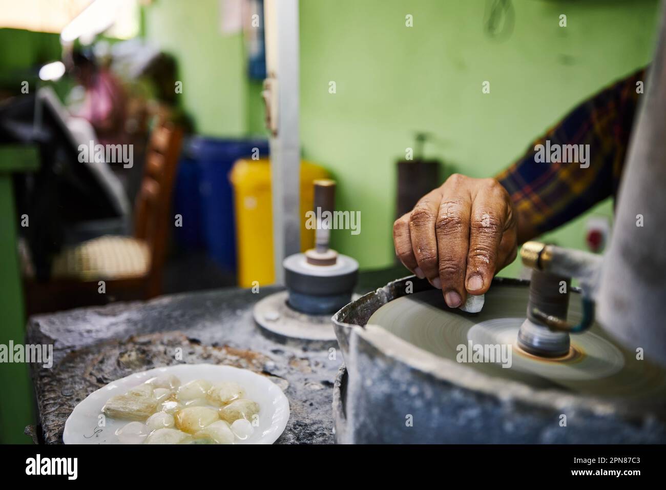Hand of jeweler is processing Moonstone, which is mined from mine in