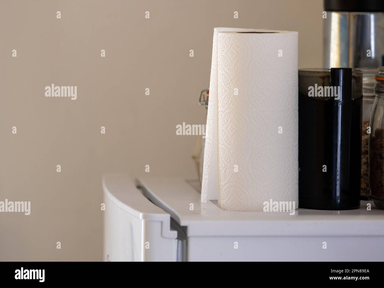 Items kept on top of a fridge/freezer including a roll of kitchen paper towel and an electric coffee grinder Stock Photo