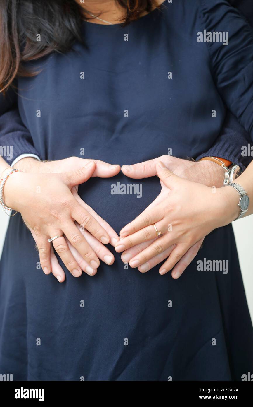 Pregnant Woman and her Man Forming Heart Shape with their Hands Stock ...