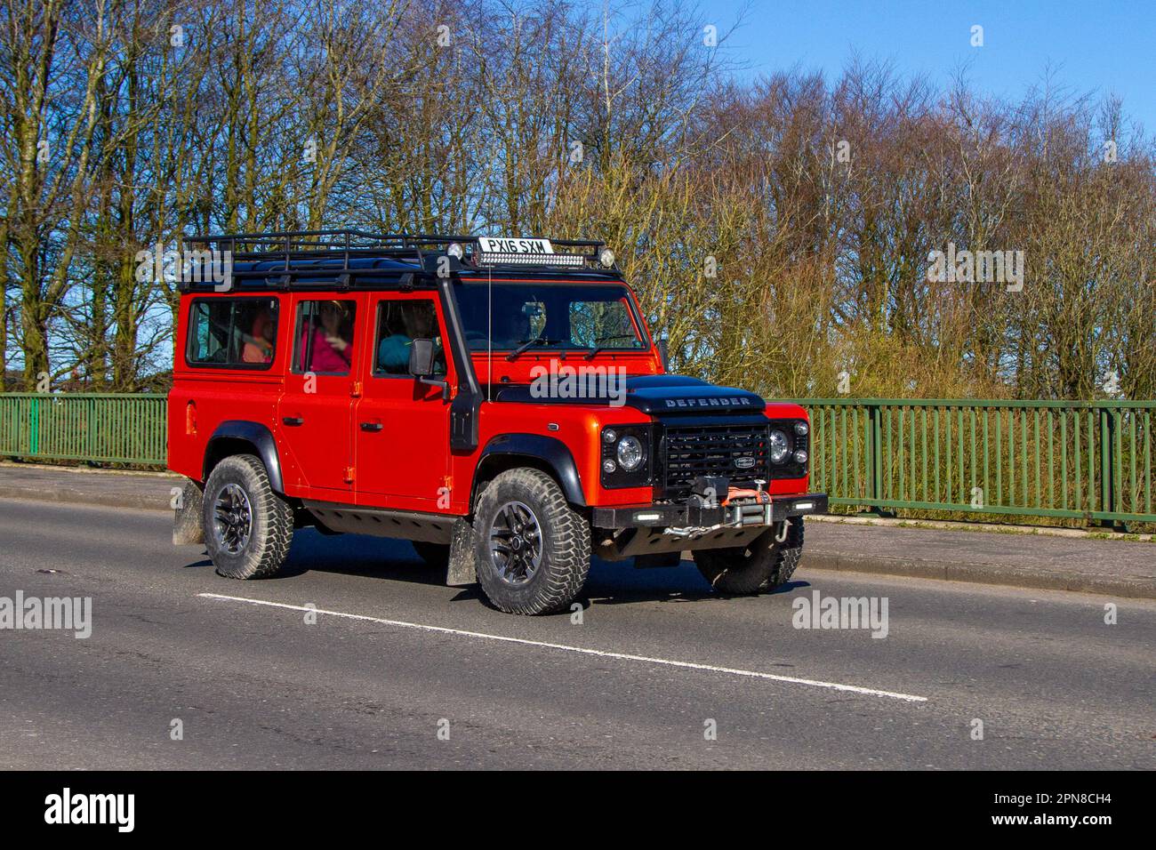 2016 Land Rover Defender 110 Adventure Td D/C 2.2 Tdci Orange LCV Station Wagon Diesel 2198 cc, with expedition-style roof rack and a winch; British-made off-road vehicle crossing motorway bridge in Greater Manchester, UK, Stock Photo