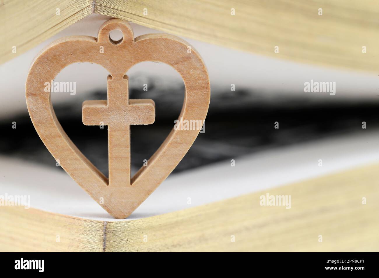 Bible with wooden heart with christian cross. Love and religion concept ...