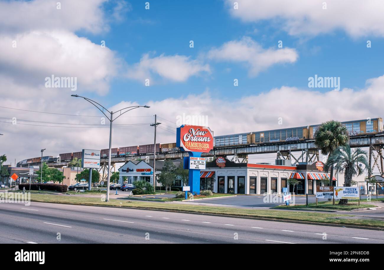 HARAHAN, LA, USA - MARCH 23, 2023: Suburban scene with fast food restaurant, clinic, bank and train on a trestle Stock Photo