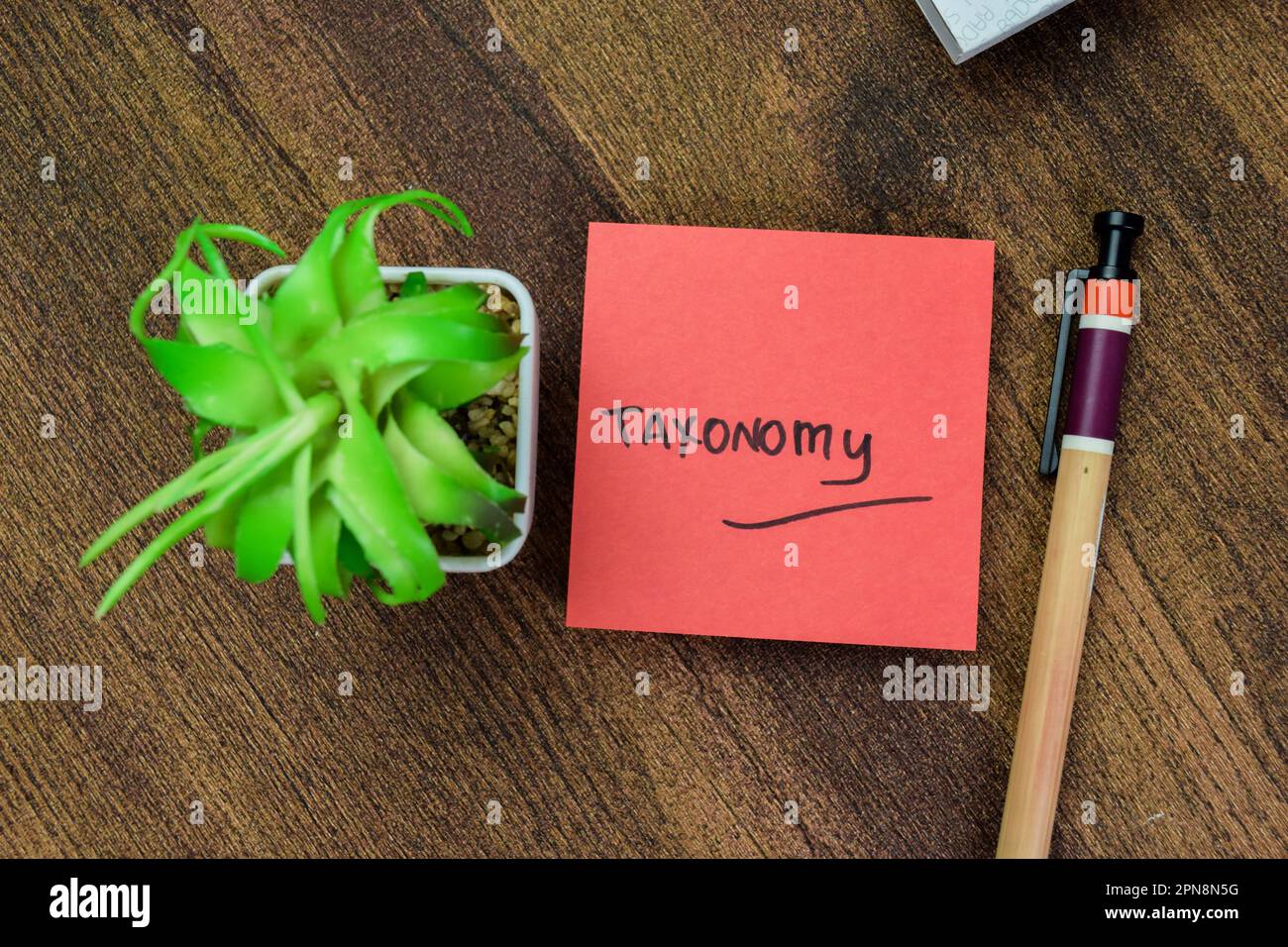 Concept of Taxonomy write on sticky notes isolated on Wooden Table. Stock Photo