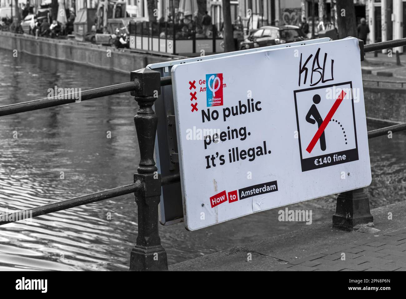 No public peeing It's illegal sign on bridge over canal at Amsterdam