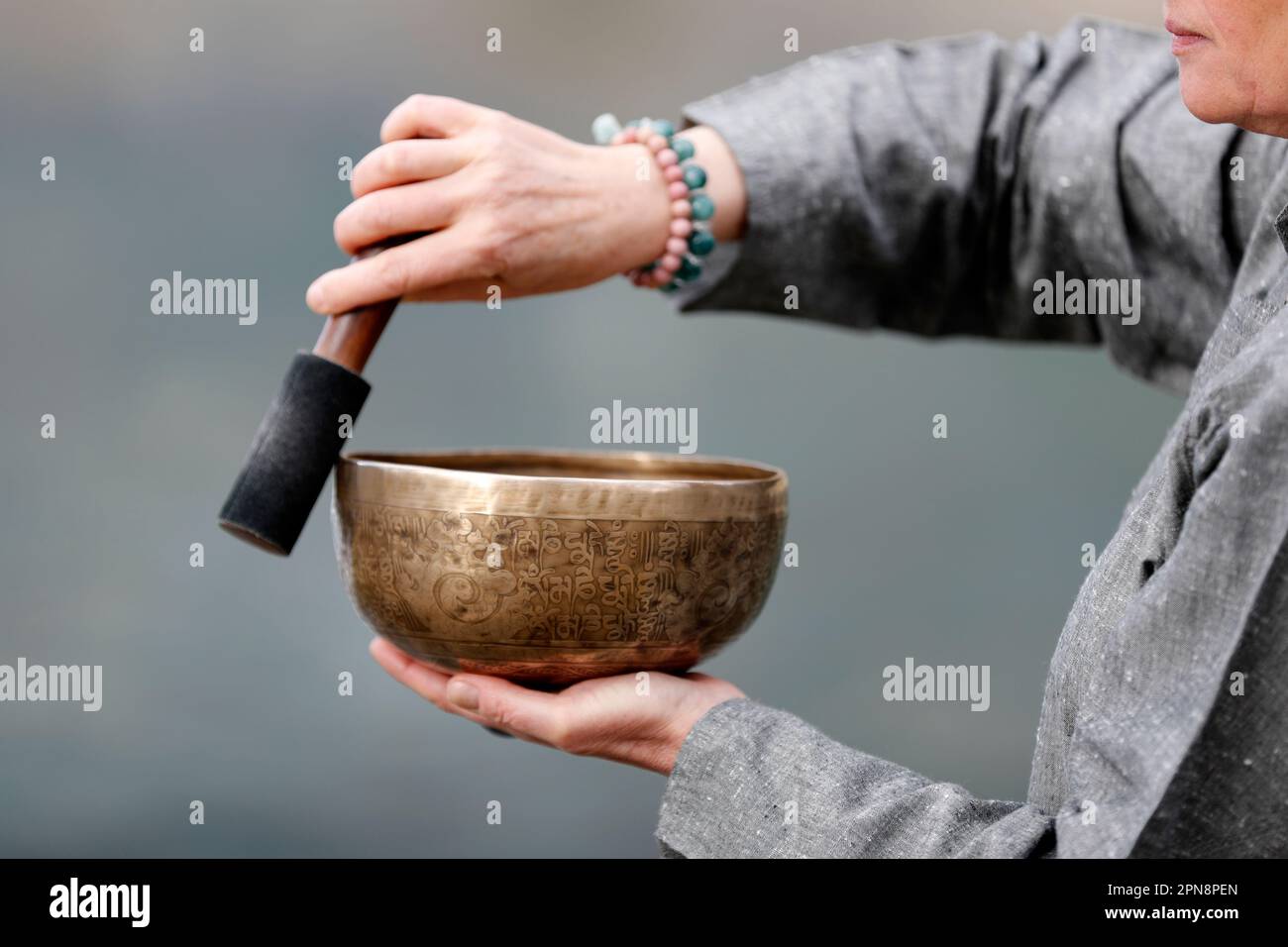 Tibetan bowl is used in sound therapy, meditation and yoga. Woman