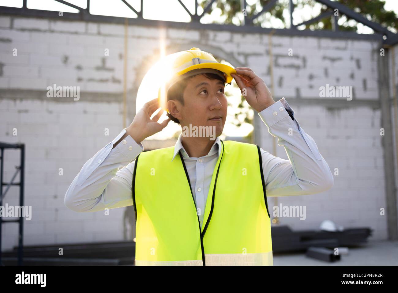 Concentrated engineer in safety vest at construction site wearing a ...