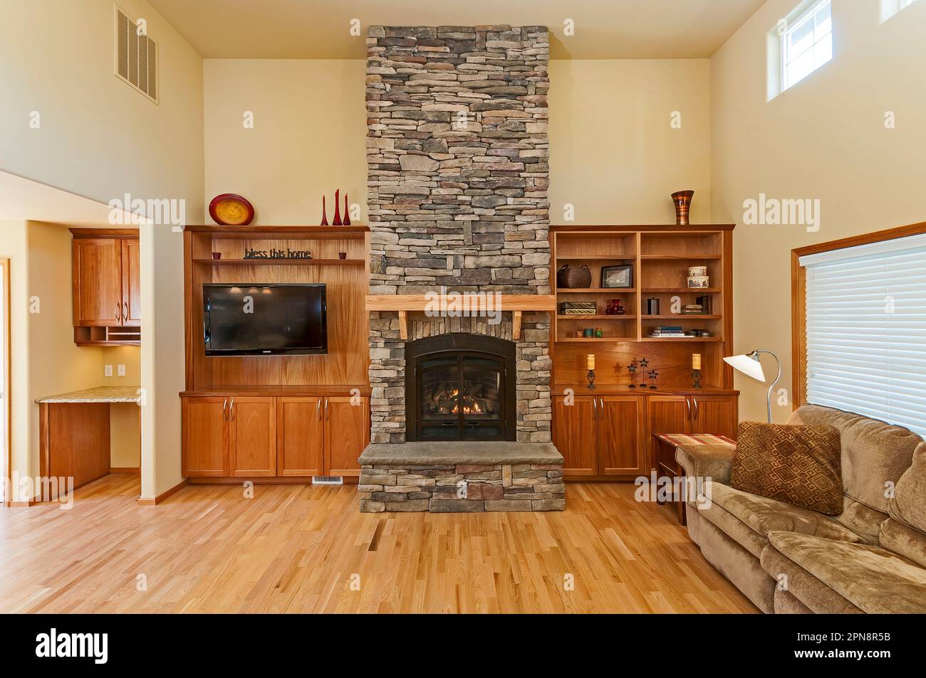 Wood hardwood flooring, and a stone fireplace in a