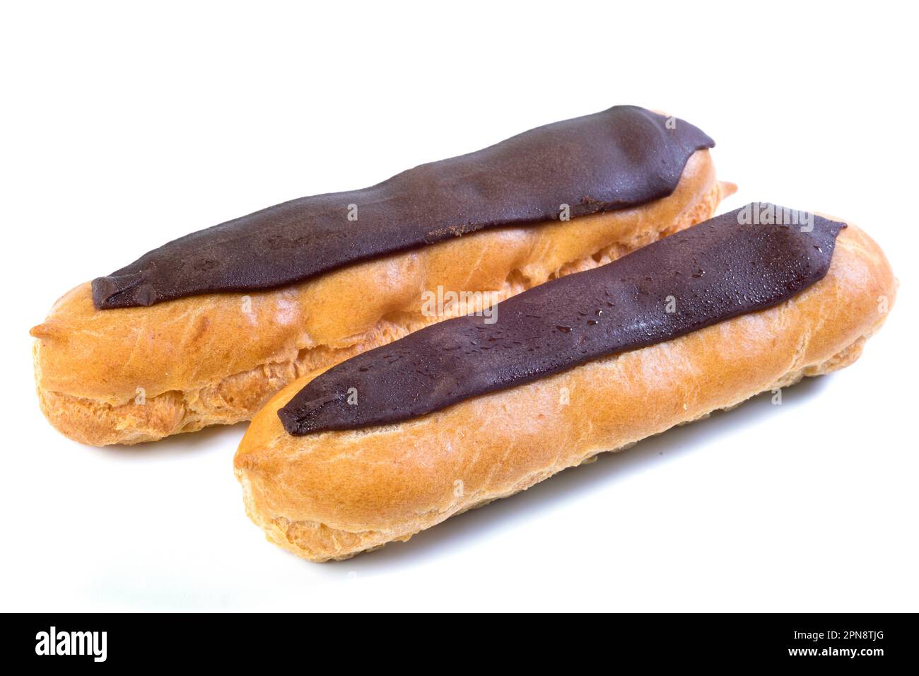 Two eclairs with dark chocolate with custard inside on a white background Stock Photo