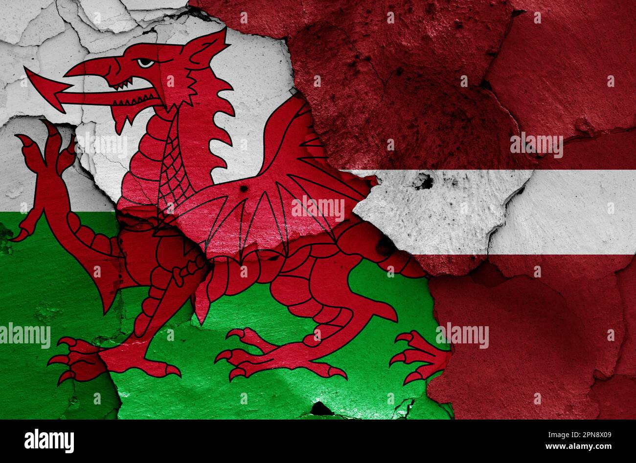 flags of Wales and Latvia painted on cracked wall Stock Photo