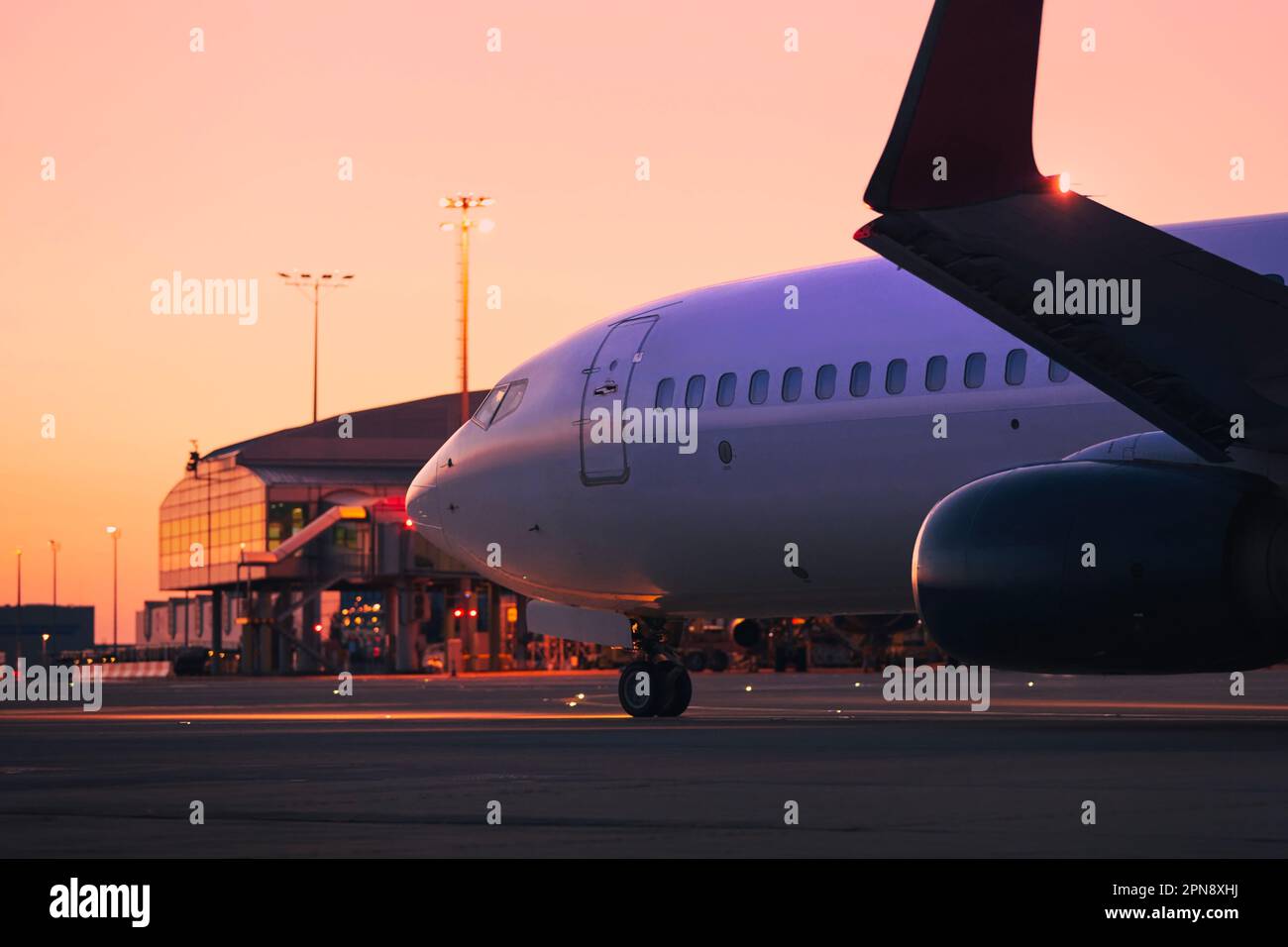 Airplane during taxiing to runway for take off. Traffic at airport at dawn. Themes travel, vacations and aviation. Stock Photo
