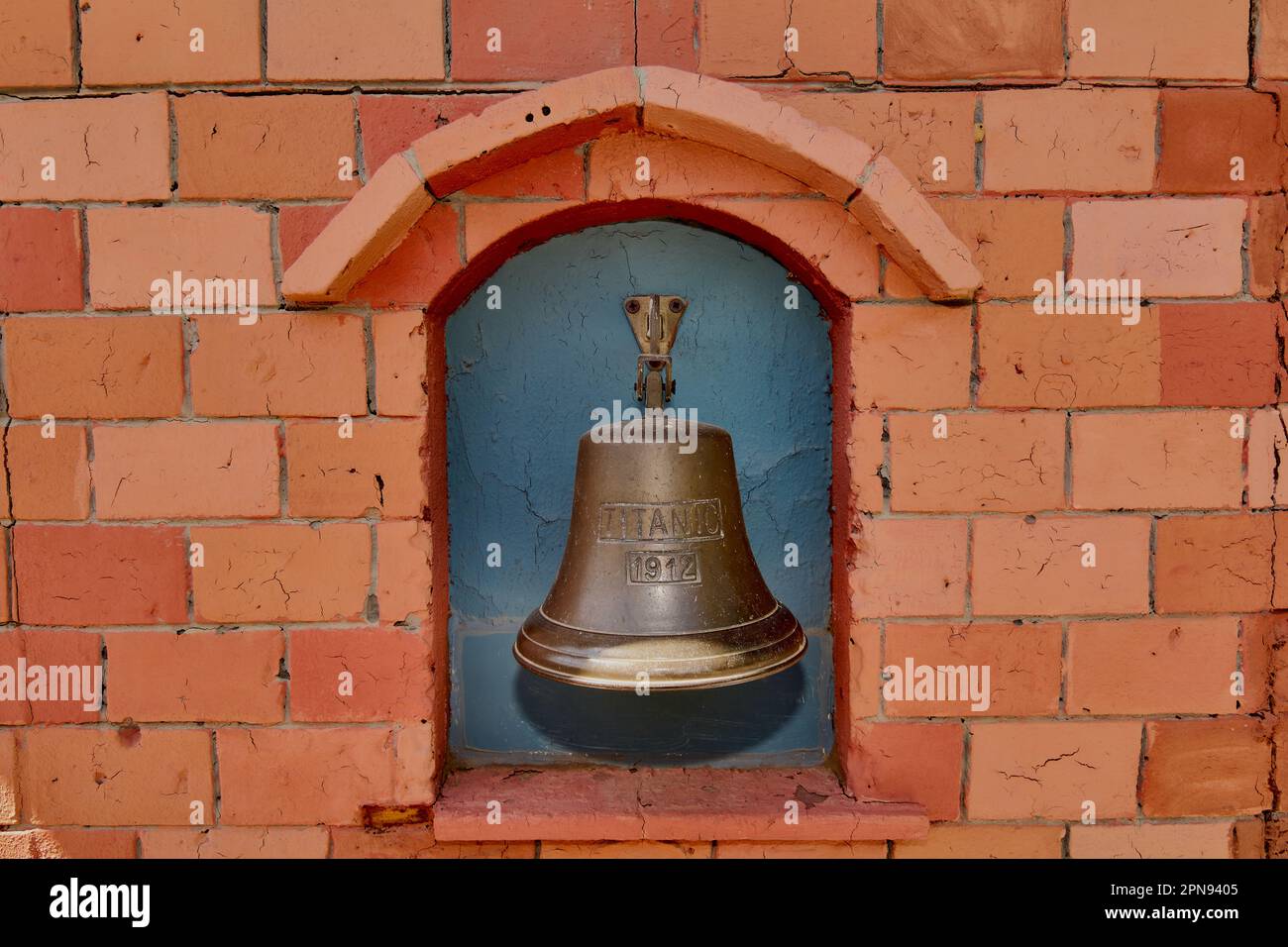 Bronze bell on a brick wall with the inscription Titanic 1912 Stock Photo