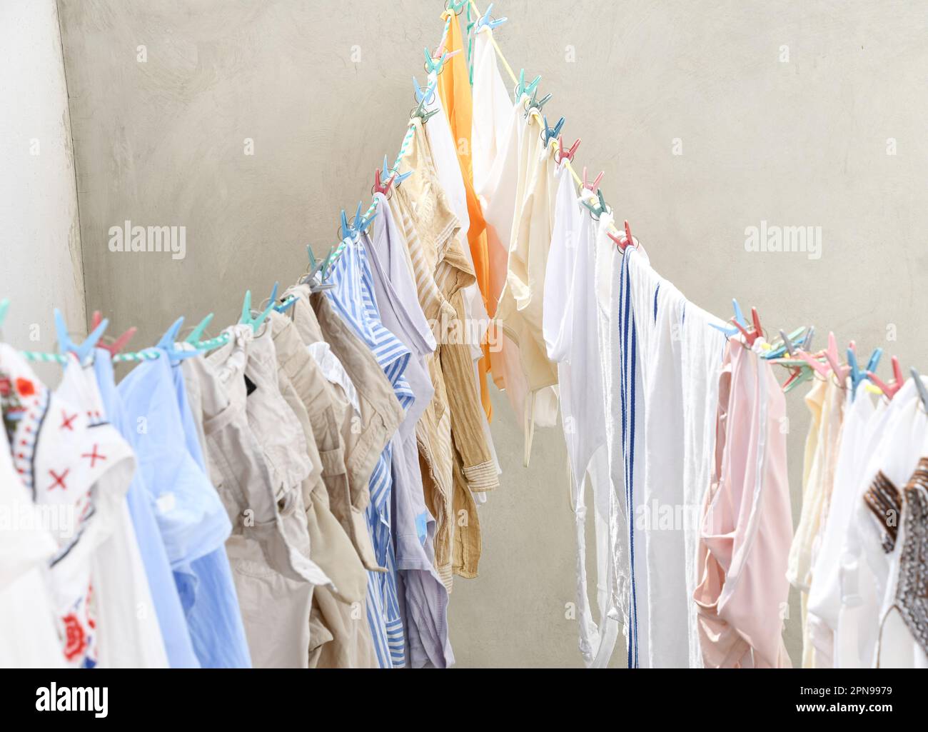 clothes hung to dry in the sun on an outside clothesline Stock Photo