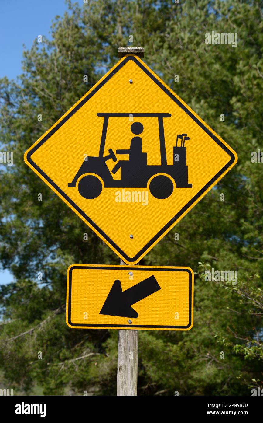 A golf cart crossing sign along a road warns motorists to watch for golfers and golf carts crossing the road in Abingdon, Virginia. Stock Photo