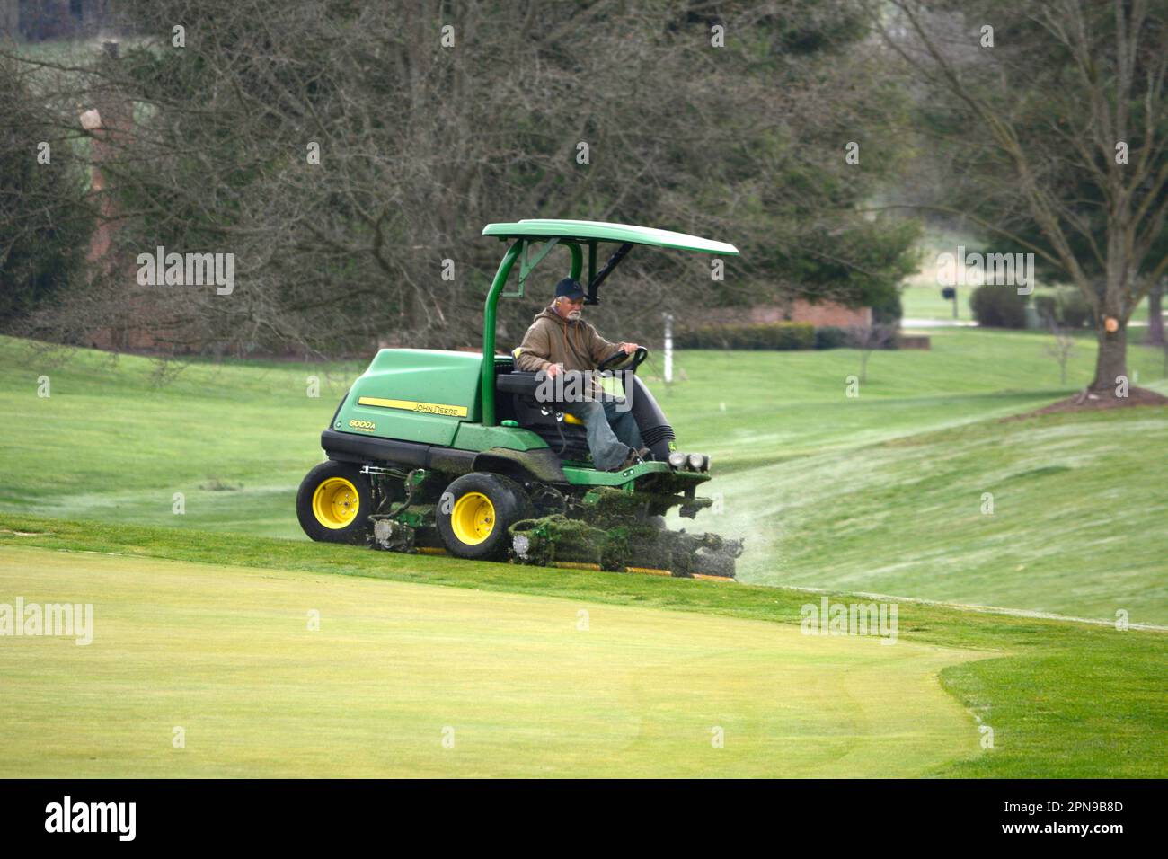A man on a riding mower mows the fairway of a golf course in Abingdon, Virginia Stock Photo