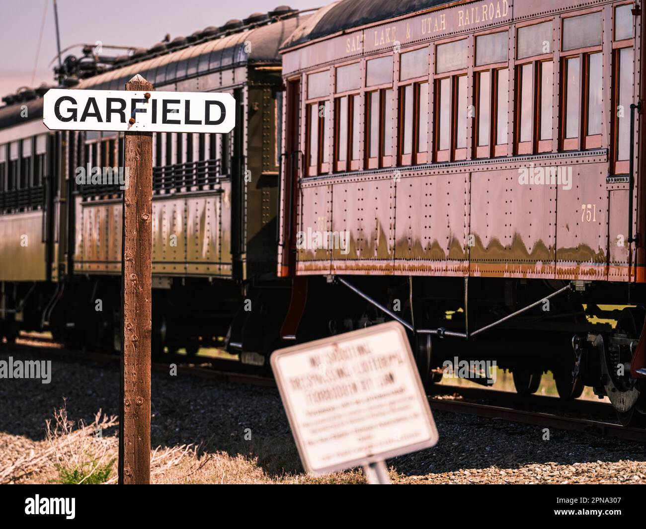 A historical railroad signage post of Garfield and a vintage passing train, California Stock Photo