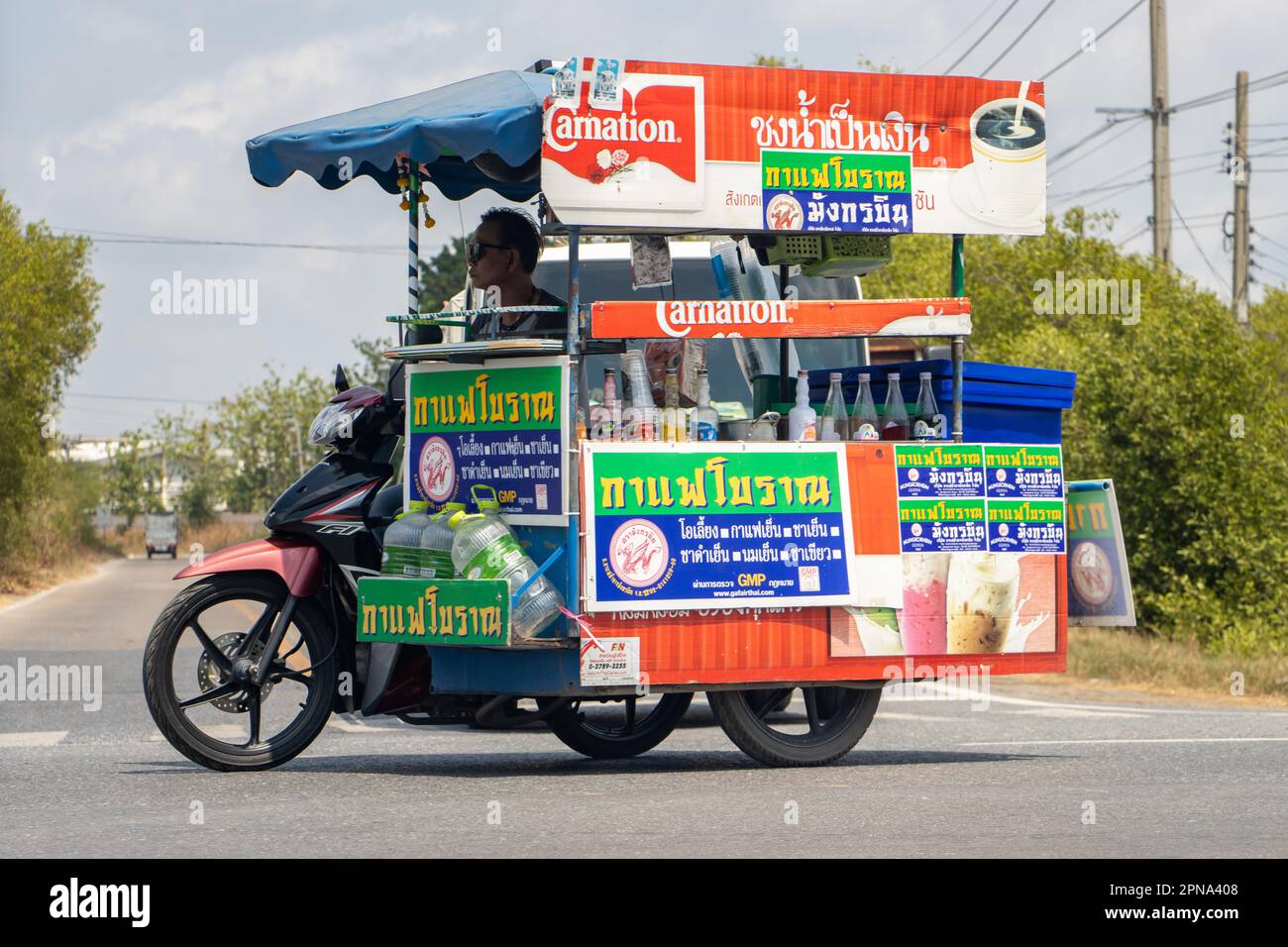 BANGKOK, THAILAND, MAR 24 2023, Seller chilled drinks drives a sidecar on the road Stock Photo