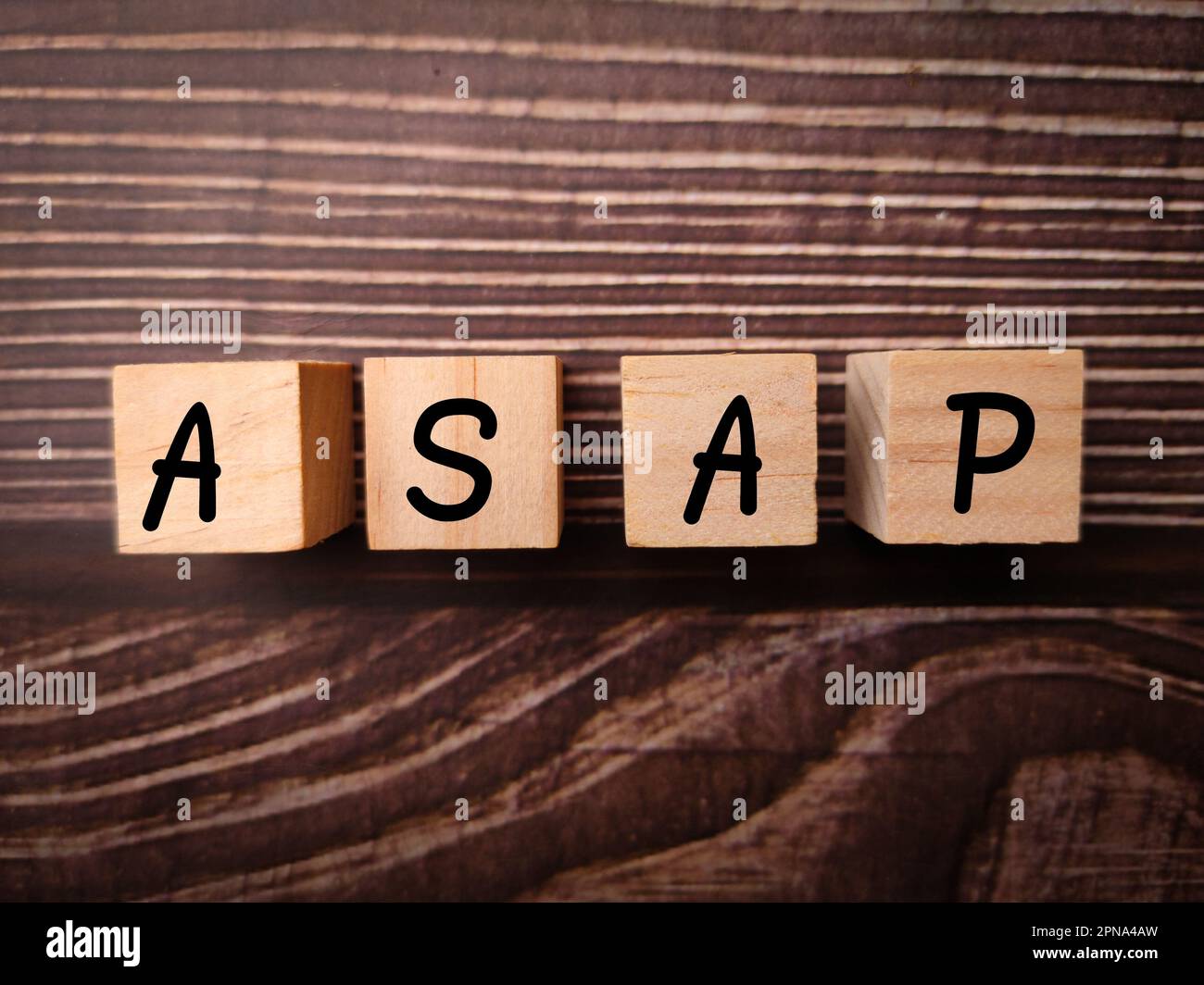 Wooden block with the word ASAP on a wooden background Stock Photo