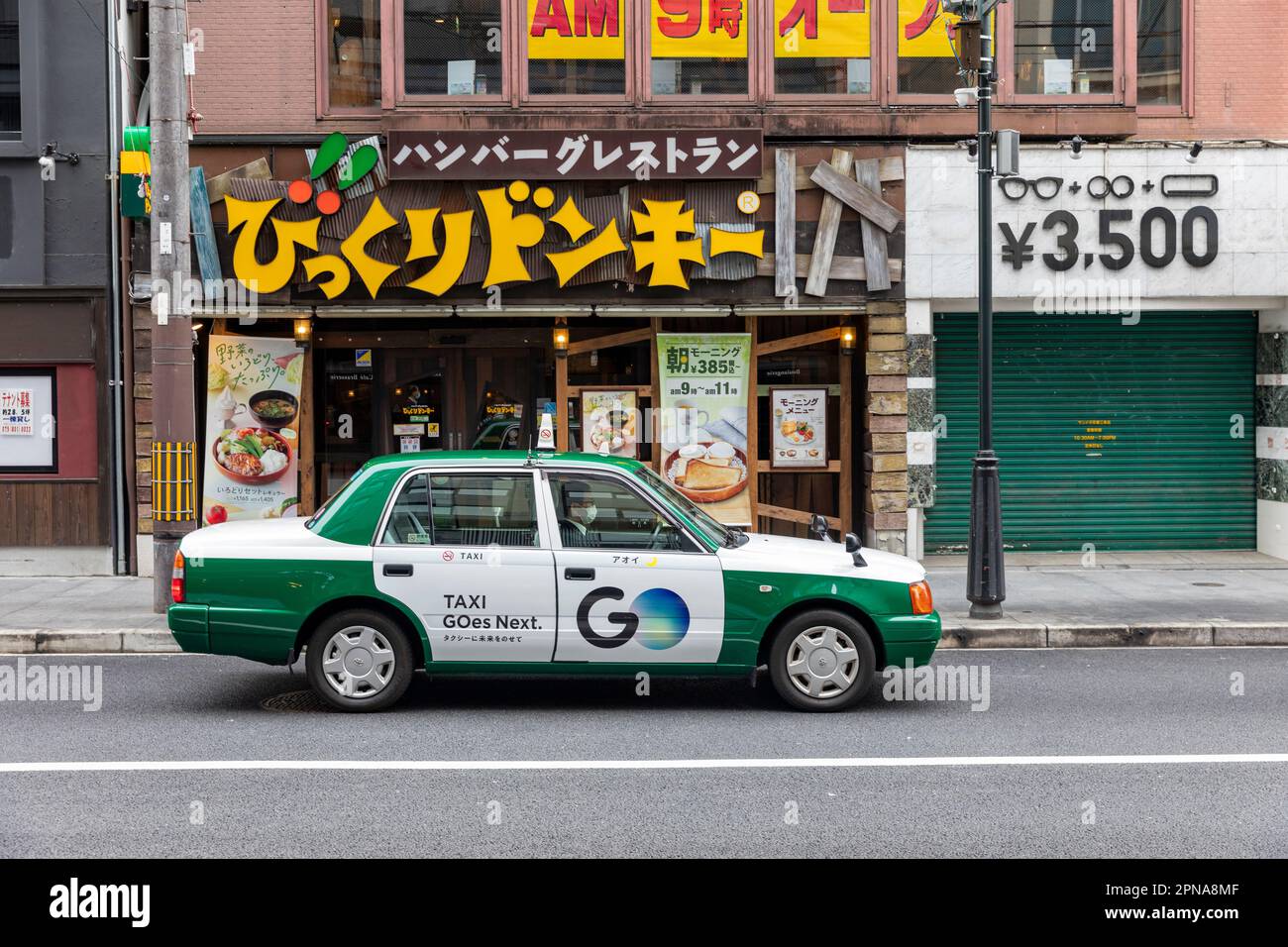 April 2023, traditional Japanese taxi a Toyota Crown four door saloon vehicle on the streets of Kyoto city centre,Japan Stock Photo