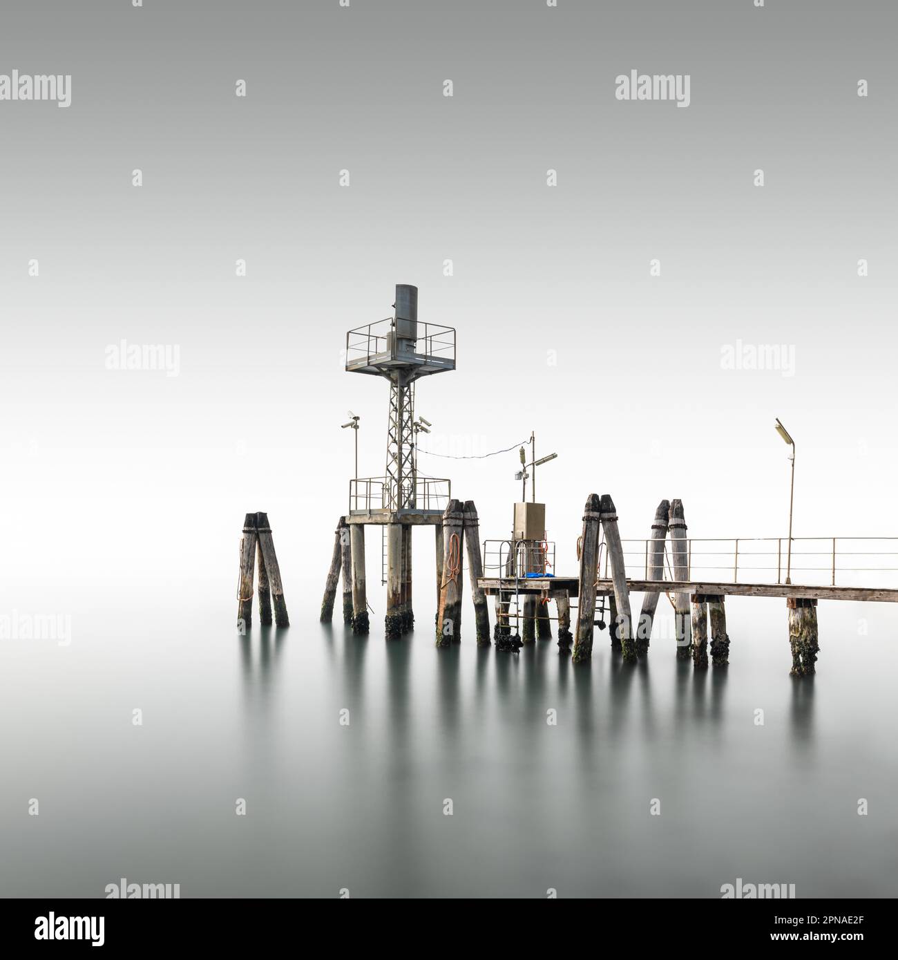 Minimalist wooden footbridge in fog in the Venice Lagoon, Italy Stock Photo