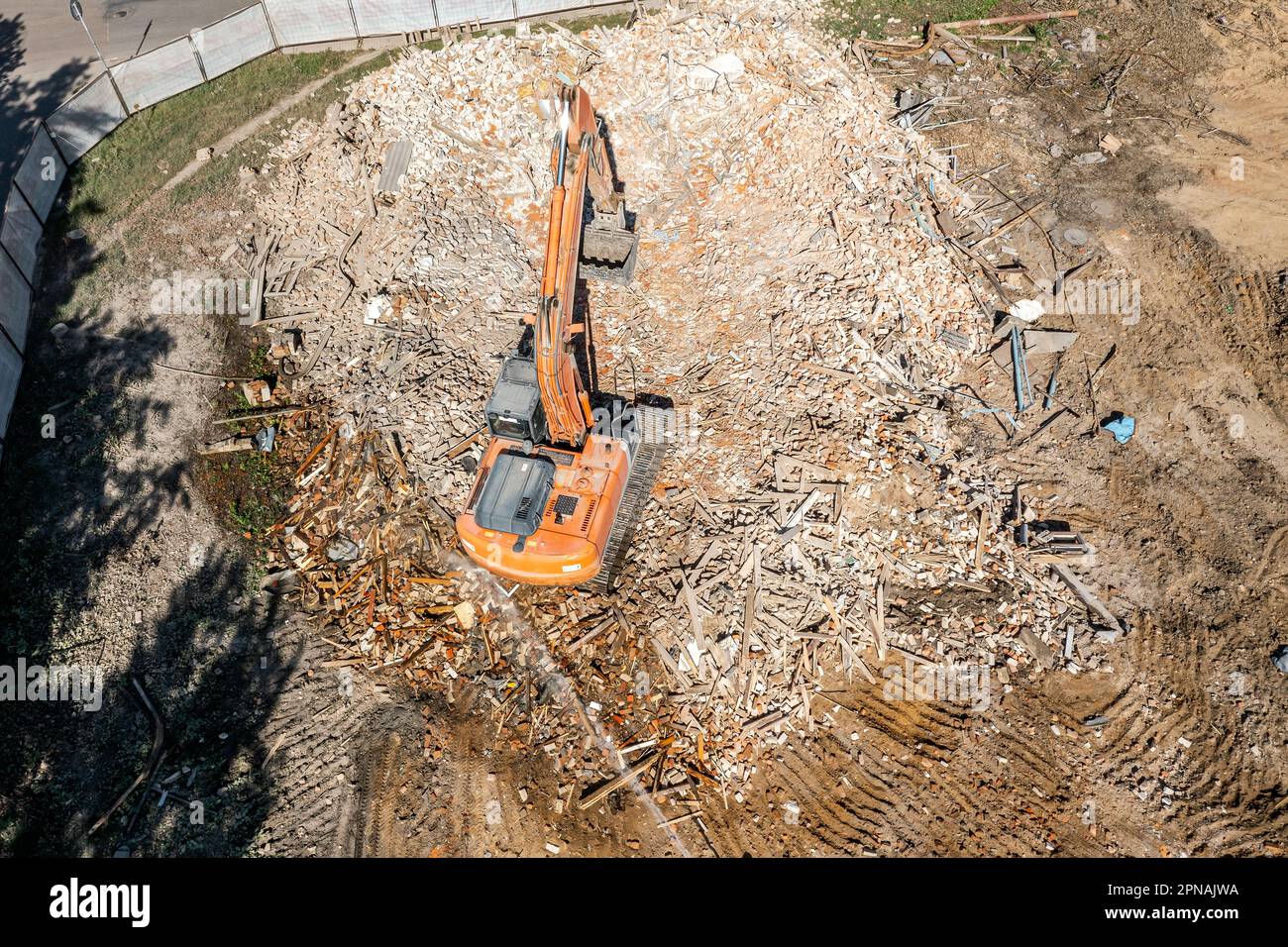 aerial view of demolition site. excavator at work in the ruins of demolished building. Stock Photo