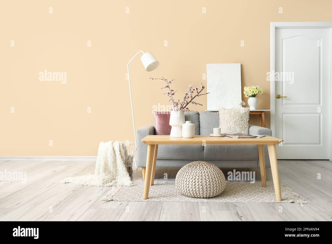 Interior of living room with grey sofa, tables and lamp Stock Photo - Alamy