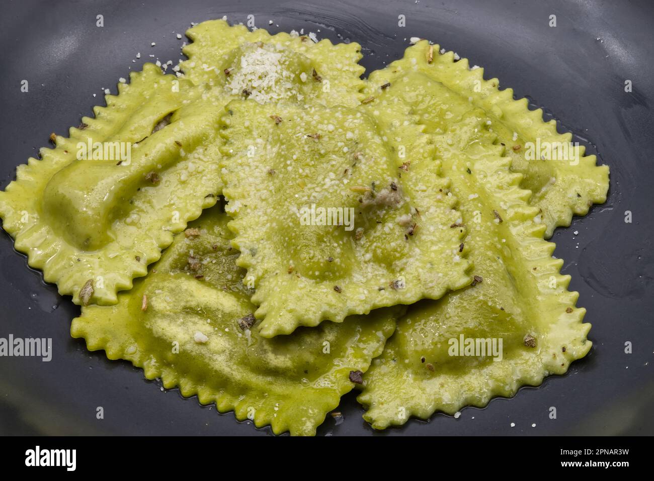 Italian Tortelli al radicchio in a black dish. Stock Photo
