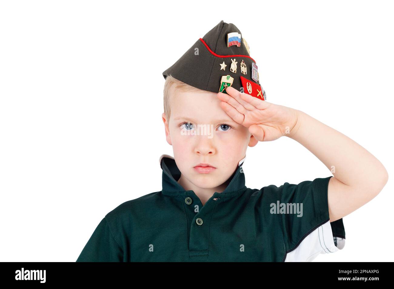 Young caucasian boy saluting playing dressups in green 'army' shirt and