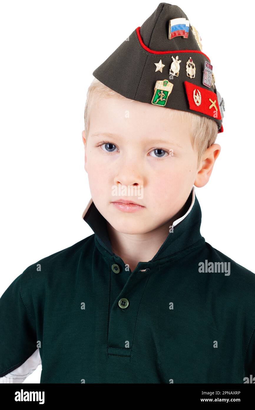 Solemn young caucasian boy playing dressups in green 'army' shirt and
