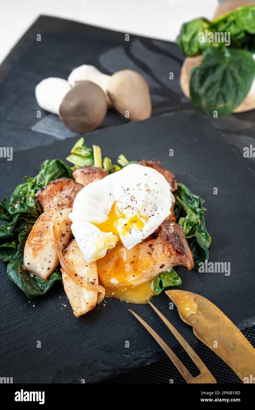 Grilled Pleurotus eryngii mushrooms with poached egg and spinach. Hot