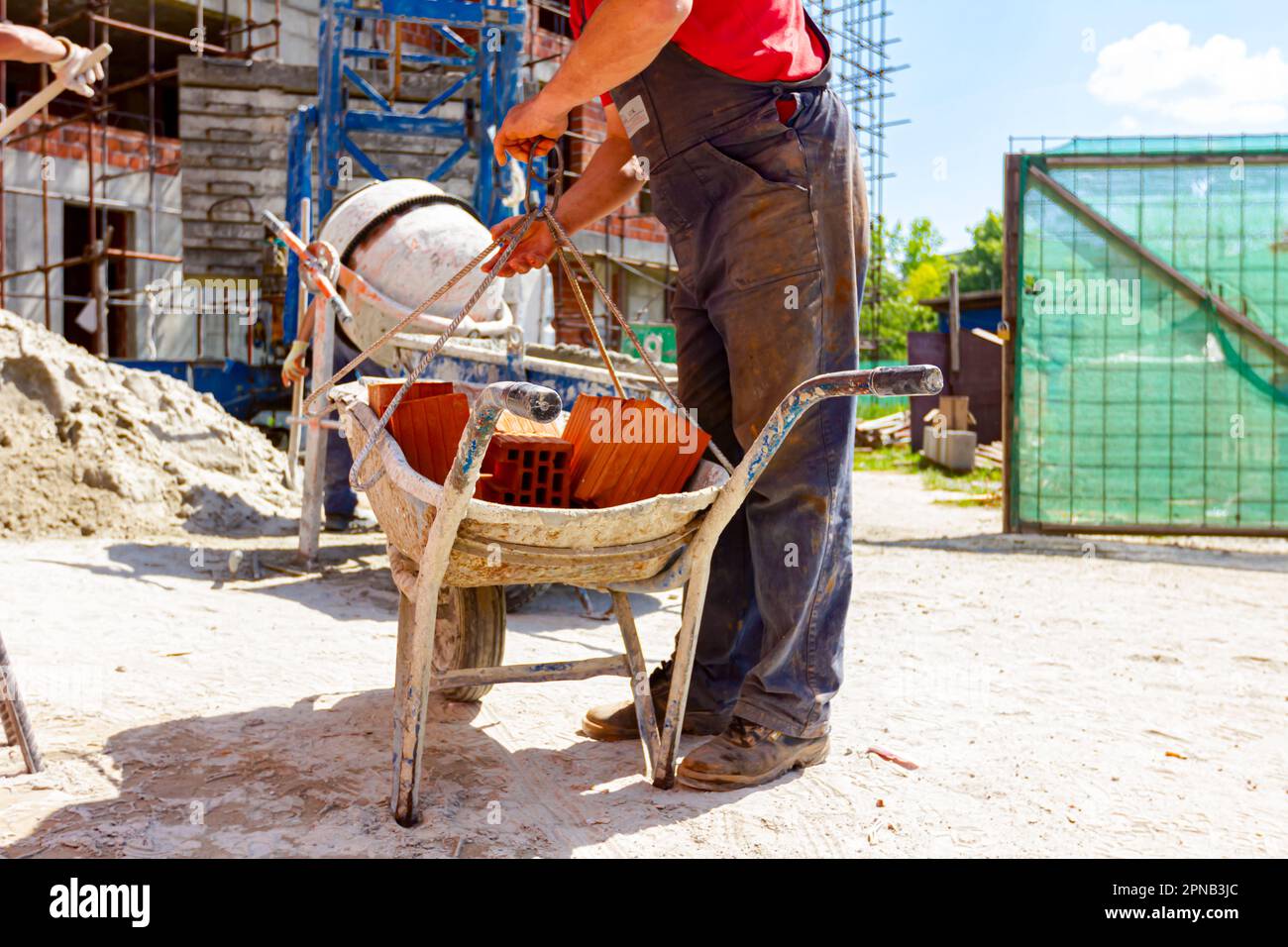Construction worker is attaching crane hooks to industrial tipping